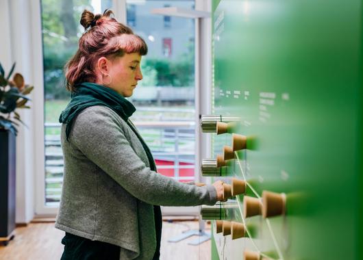 Eine Frau steht an einem Ausstellungsstück der Innoklusio Ausstellung.