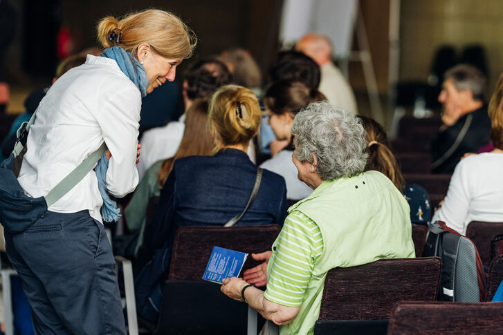 Das Bild zeigt zwei Frauen im Gespräch miteinander bei einer Veranstaltung.