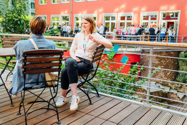 Zwei Frauen unterhalten sich am Tisch auf der Außenfläche der GLs Bank Kantine am Hauptsitz in Bochum.